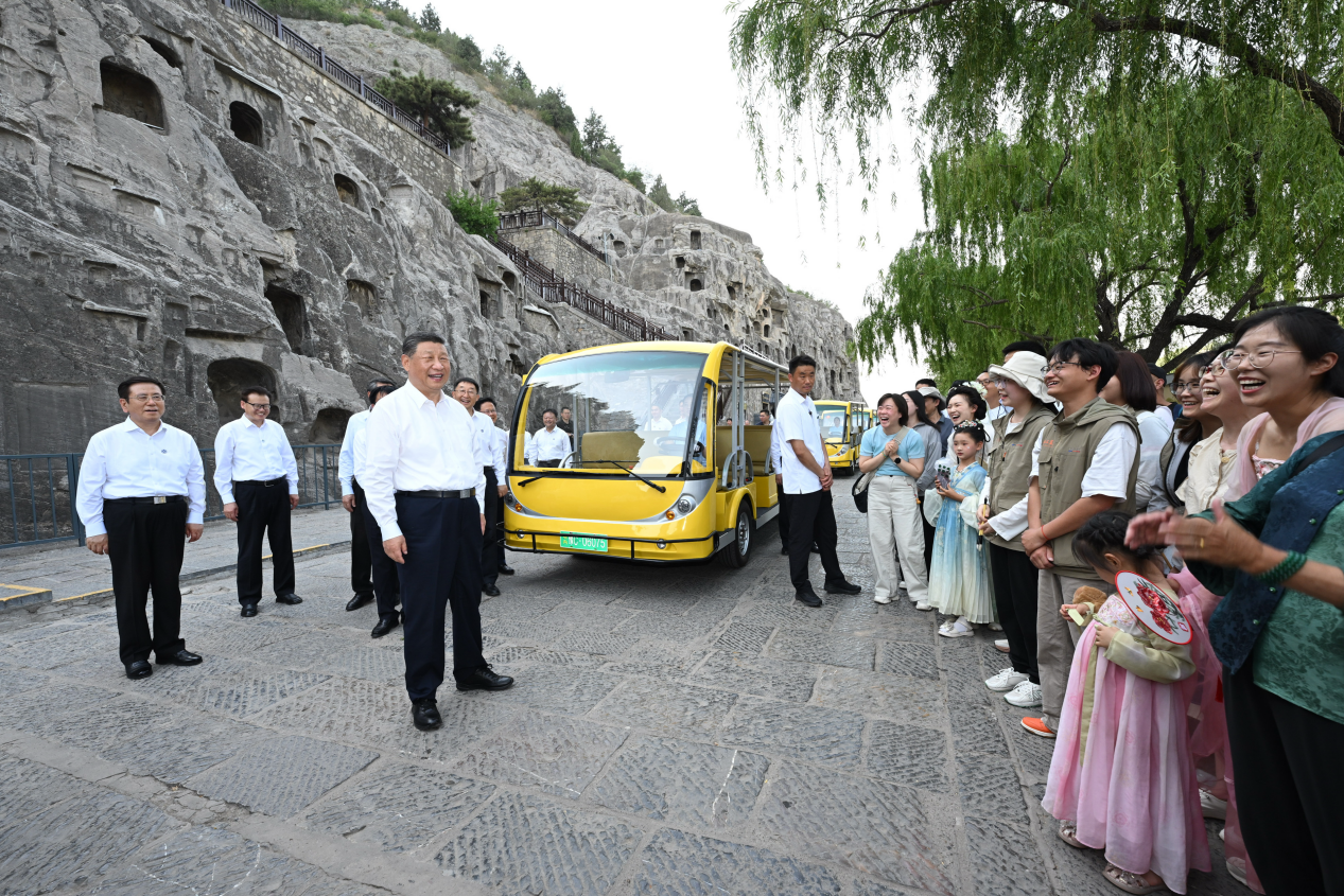 5月19日，習近平在洛陽龍門石窟考察時，同游客親切交流。